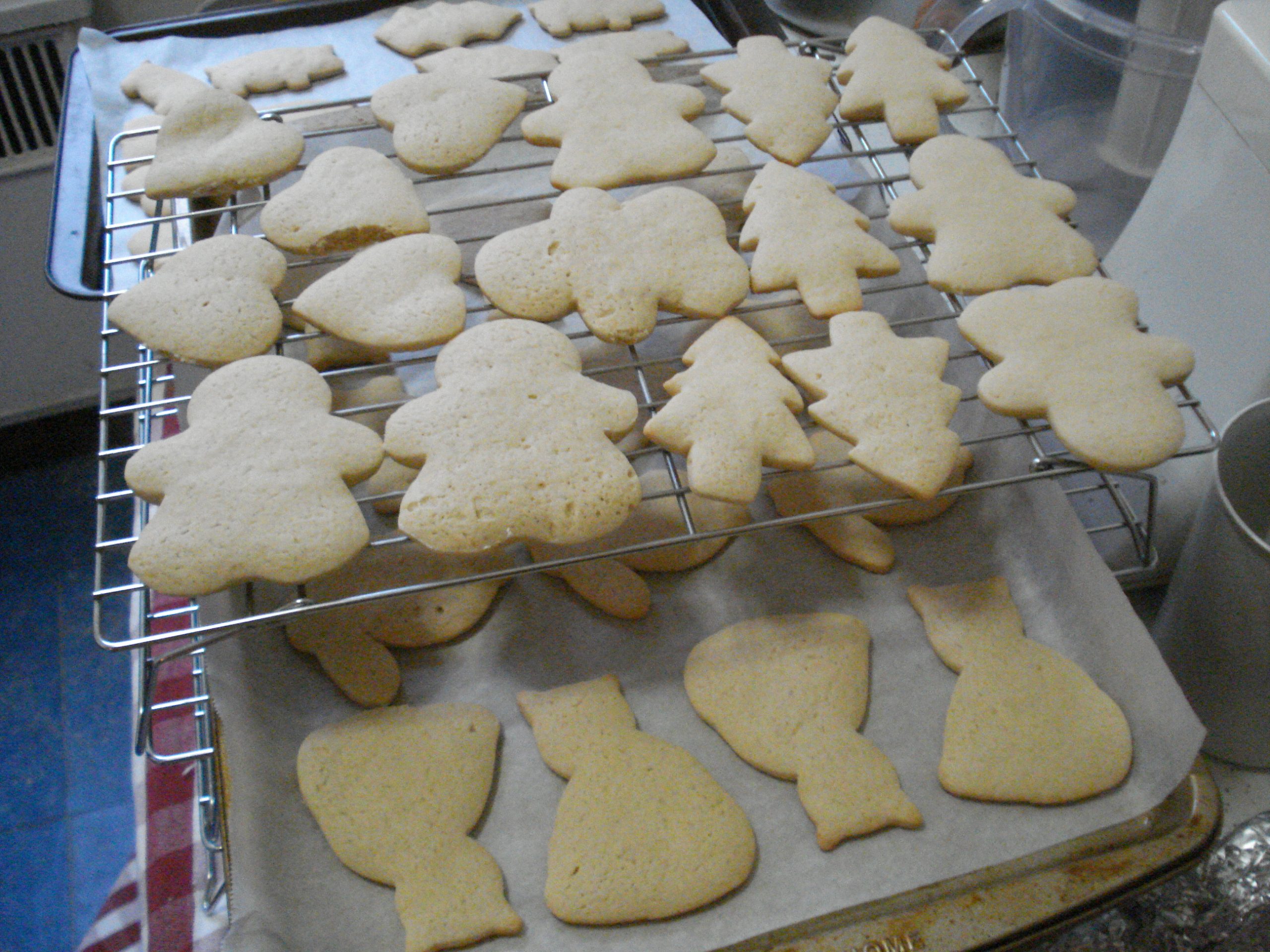 Home-baked cut-out sugar cookies cooling on a wire rack over a baking tray