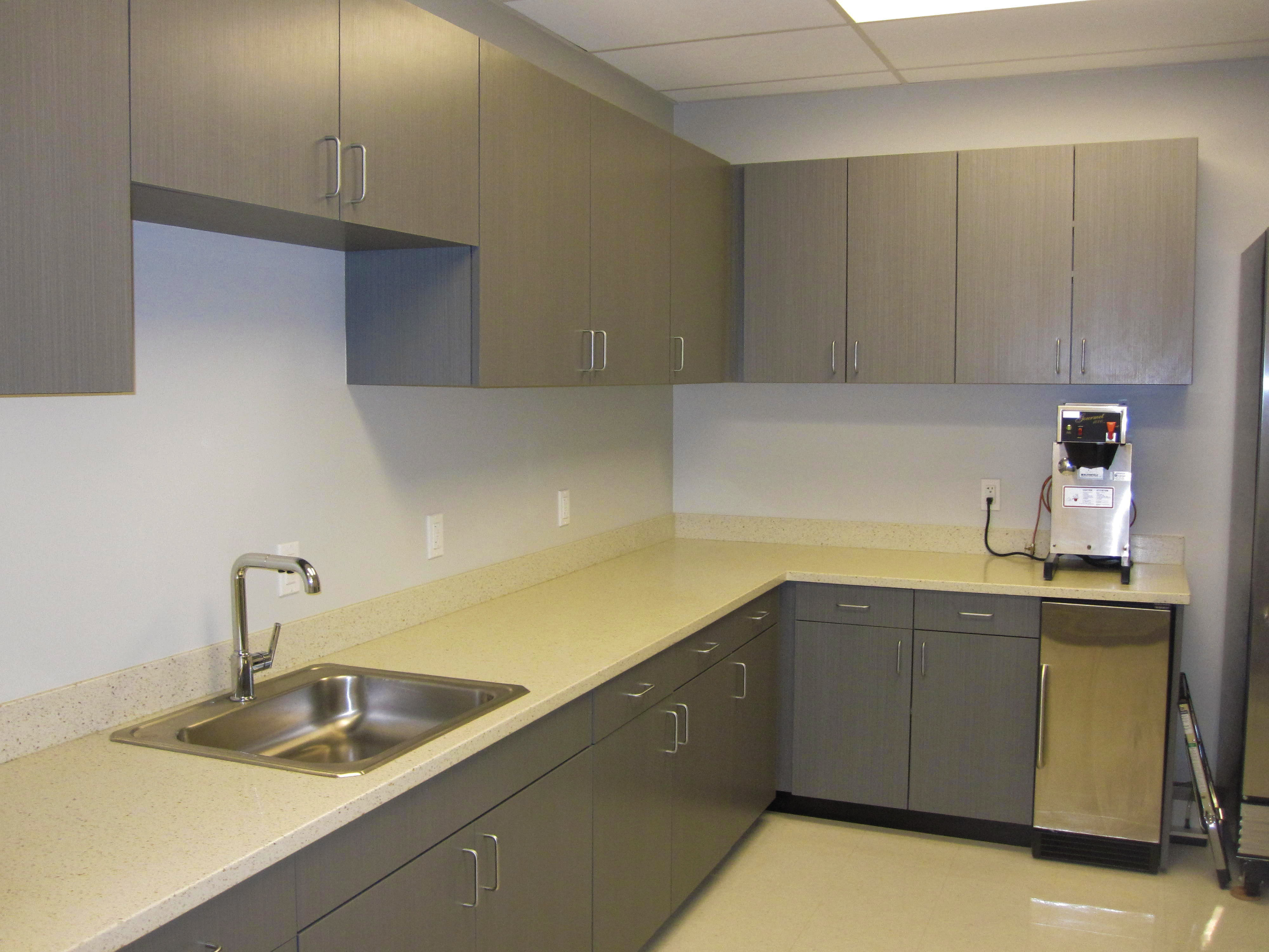 Clean prep room with a stainless sink, long counter and grey cabinets, the kind of space a commissary kitchen agreement might cover